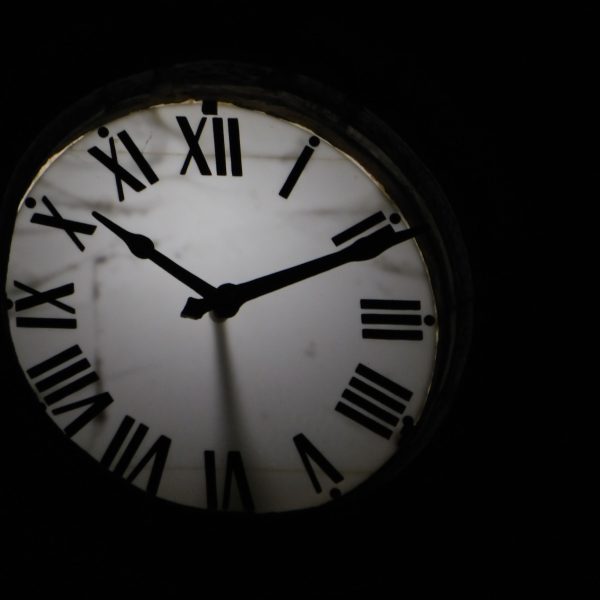 Horloge mécanique ronde flèches noires fond obscur