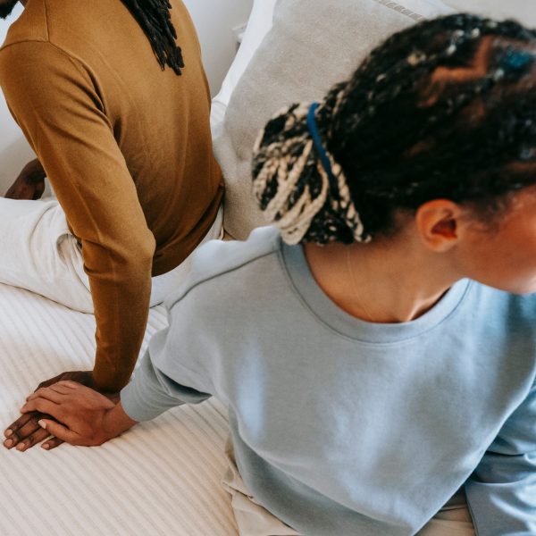 Couple triste allongé au lit se tenant la main