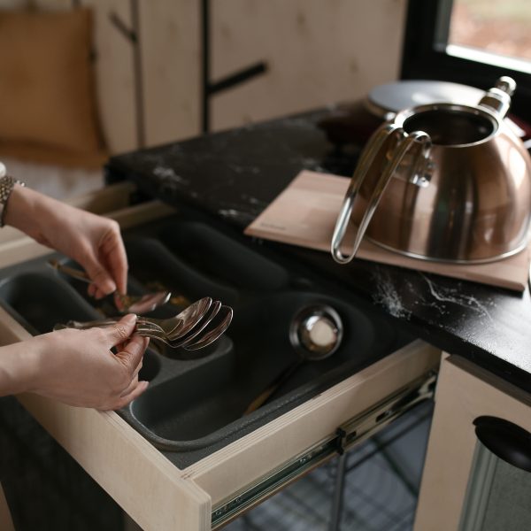 Femme organisant cuillères dans tiroir cuisine