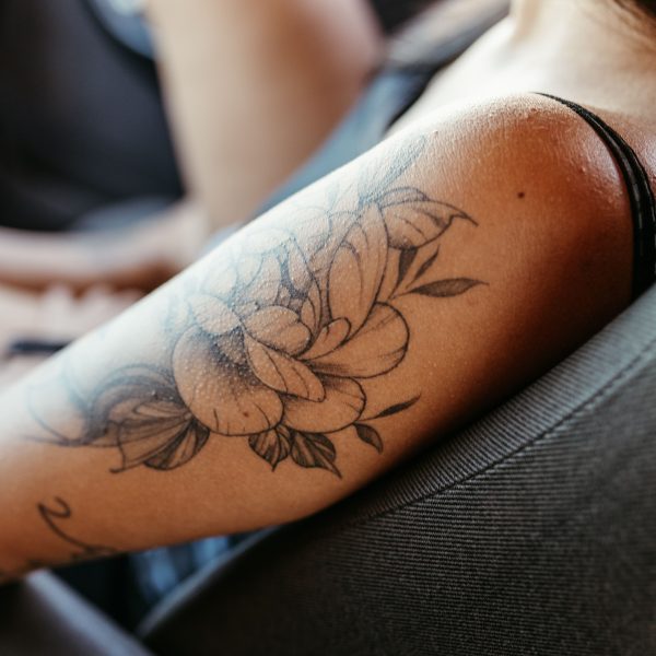 Femme avec tatouage floral détaillé sur le bras
