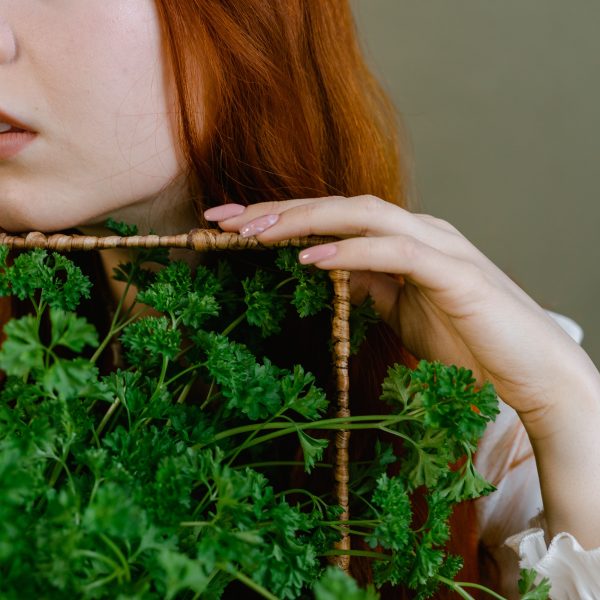 Femme aux cheveux rouges tenant du persil frais