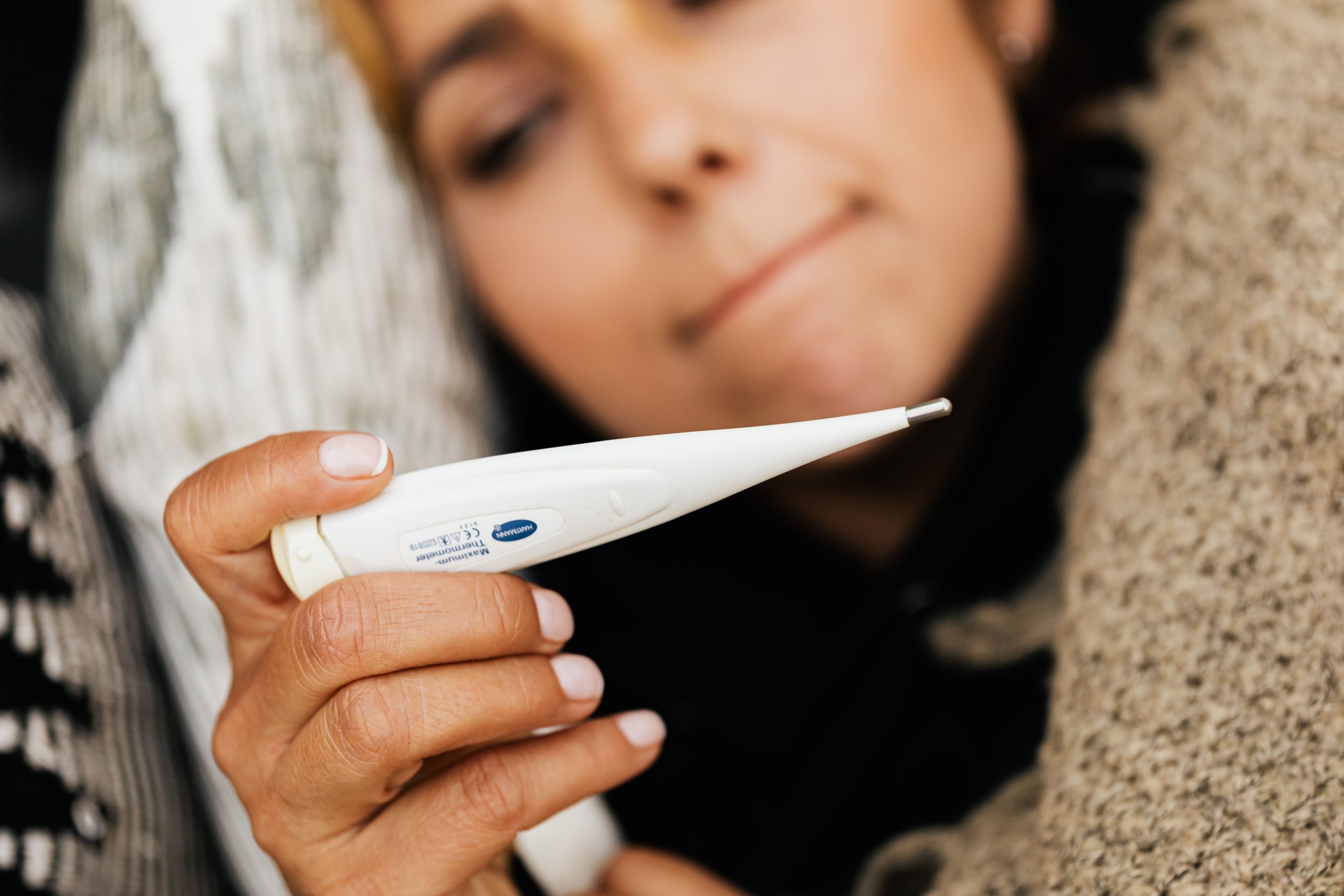 Femme malade tenant un thermomètre digital