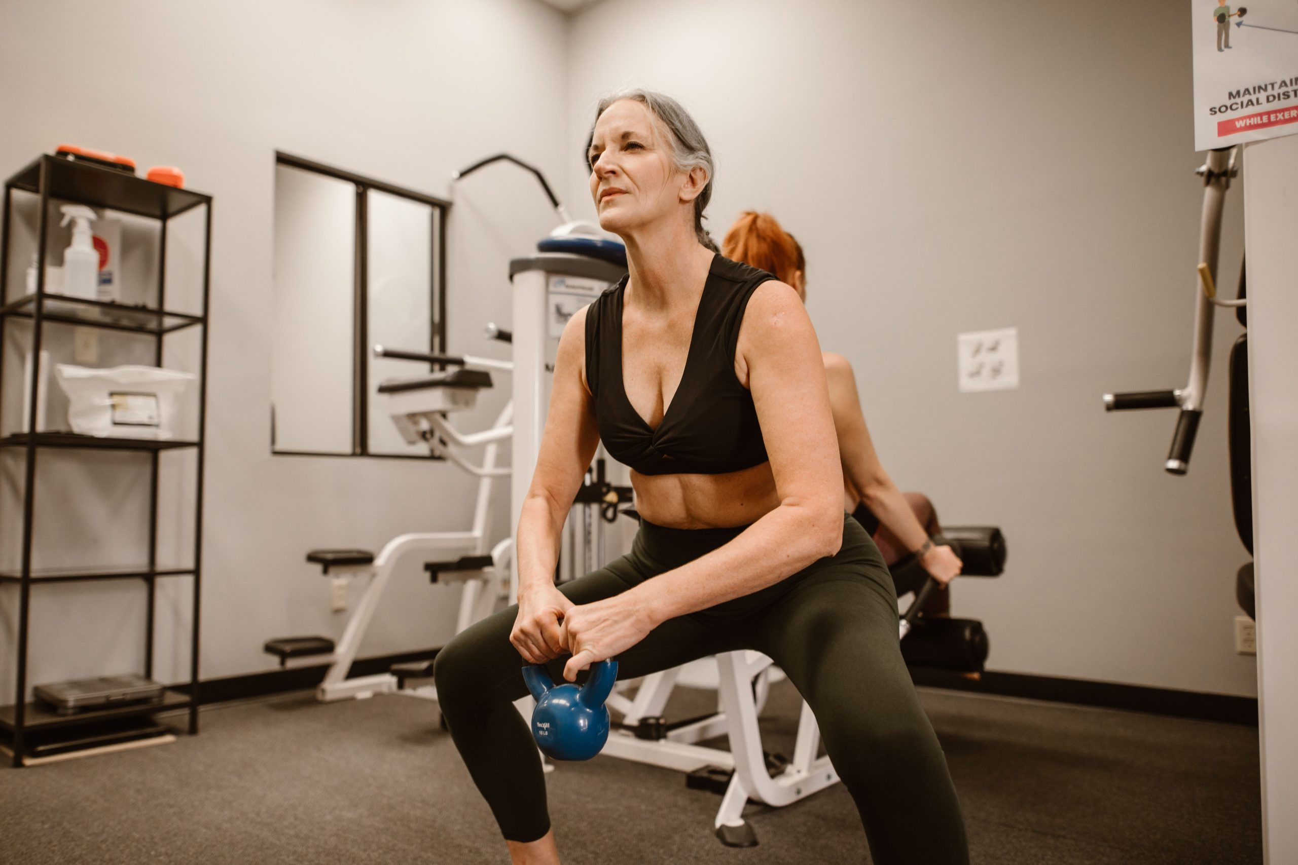 Femme senior pratiquant kettlebell squats fitness