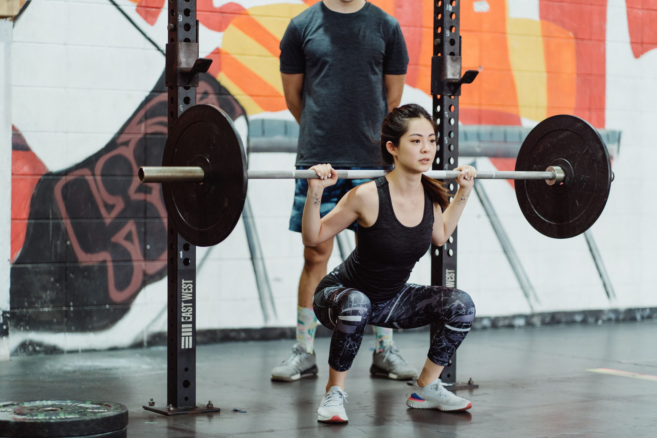 Femme effectuant des squats avec poids en salle