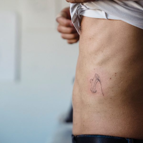 Gros plan tatouage couronne minimaliste sur flanc